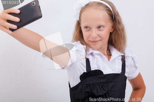Image of pretty teen girl taking selfies with her smart phone