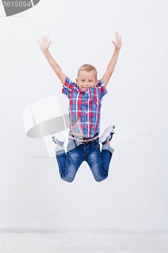 Image of happy young boy jumping  on white background