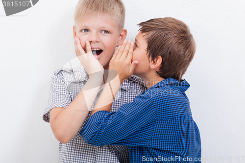 Image of Teenage boy whispering in the ear a secret to friendl on white  background