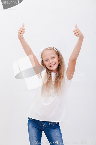 Image of Portrait of a beautiful girl showing thumbs up on white