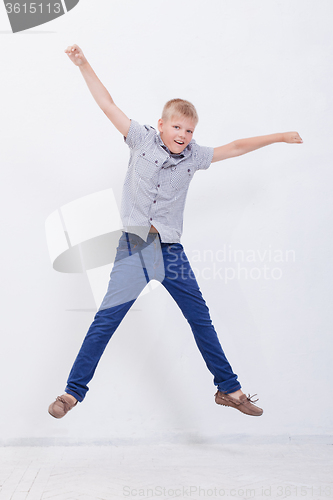 Image of happy young boy jumping  on white background