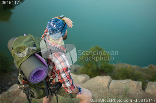 Image of Young caucasian man with backpack on the top of hill