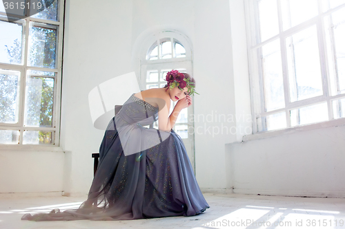 Image of The beautiful ballerina sirtting in long gray dress 