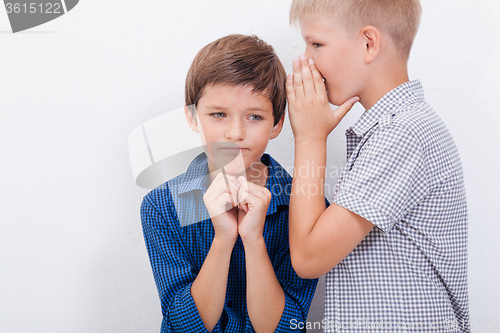 Image of Teenage boy whispering in the ear a secret to friendl on white  background