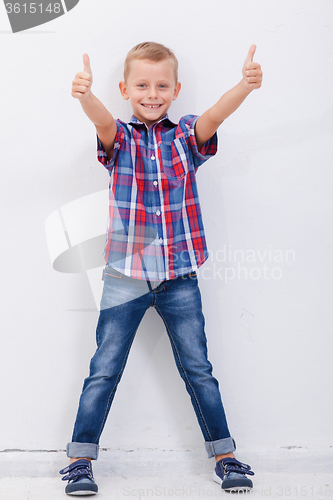 Image of Portrait of happy boy showing thumbs up gesture