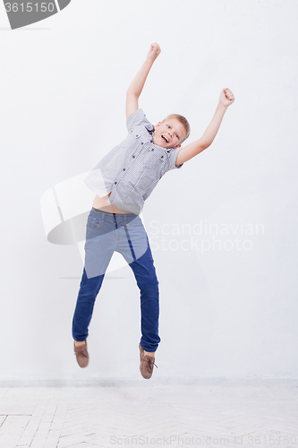 Image of happy young boy jumping  on white background