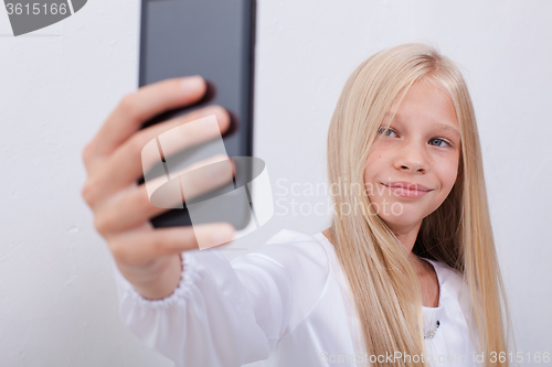 Image of pretty teen girl taking selfies with her smart phone