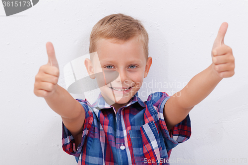 Image of Portrait of happy boy showing thumbs up gesture