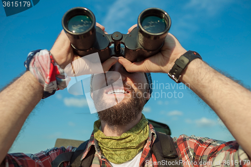 Image of Young caucasian man with backpack standing on the top of hill