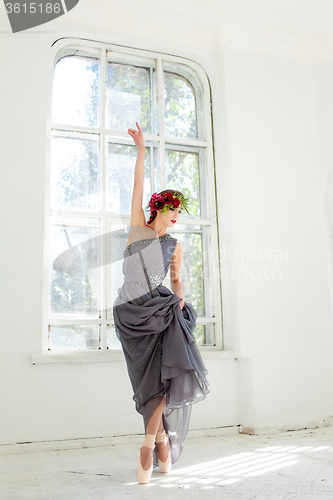 Image of The beautiful ballerina dancing in long gray dress 