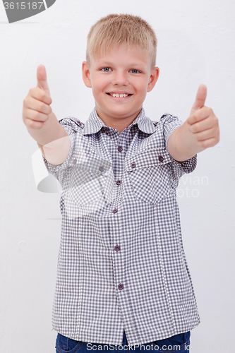 Image of Portrait of happy boy showing thumbs up gesture