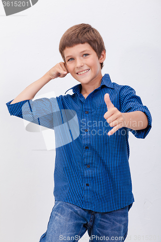 Image of Happy young boy with calling gesture over white background