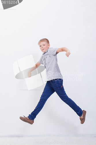 Image of happy young boy jumping  on white background