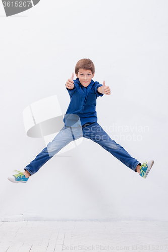 Image of happy young boy jumping  on white background