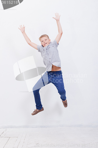 Image of happy young boy jumping  on white background