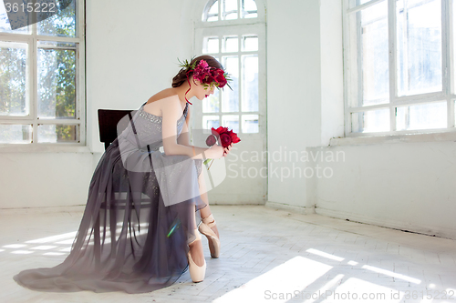 Image of The beautiful ballerina sirtting in long gray dress 