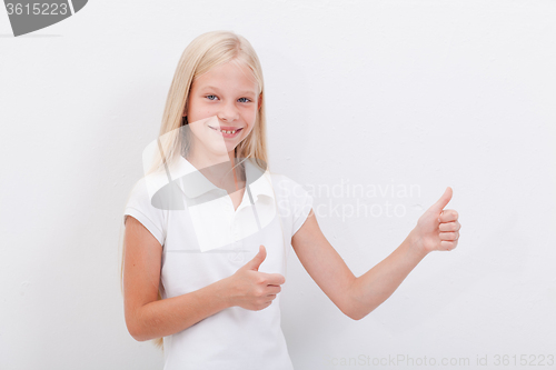 Image of Portrait of a beautiful girl showing thumbs up on white