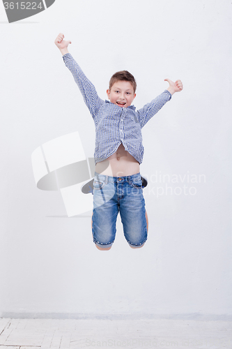 Image of happy young boy jumping  on white background
