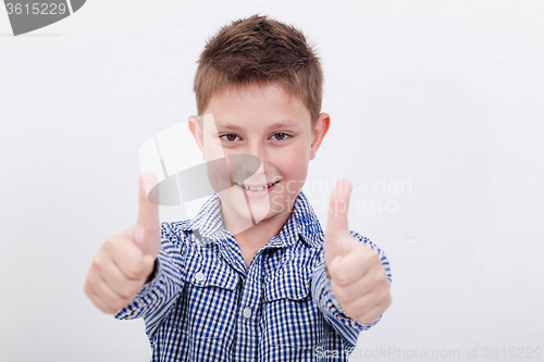 Image of Portrait of happy boy showing thumbs up gesture