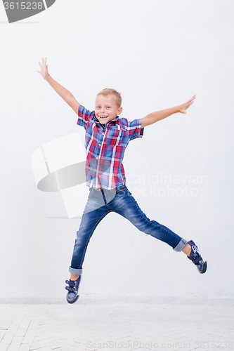 Image of happy young boy jumping  on white background