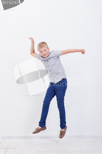 Image of happy young boy jumping  on white background