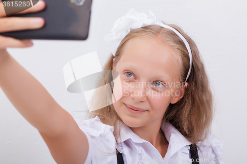 Image of pretty teen girl taking selfies with her smart phone
