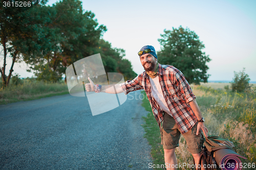 Image of Young smilimg caucasian tourist on a road.