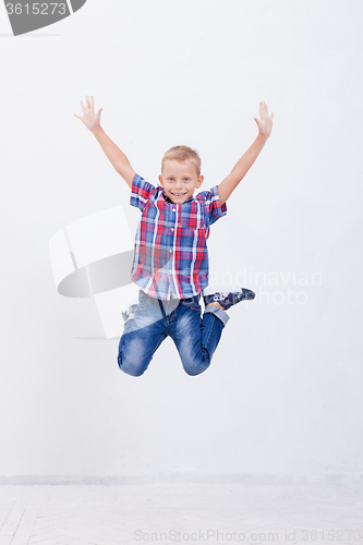 Image of happy young boy jumping  on white background