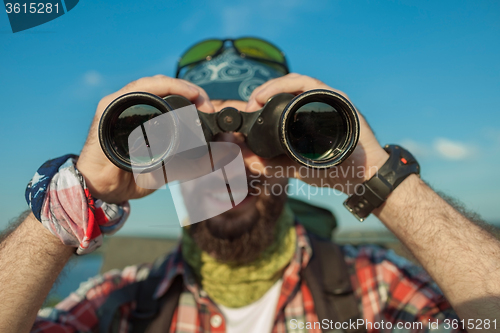 Image of Young caucasian man with backpack standing on the top of hill