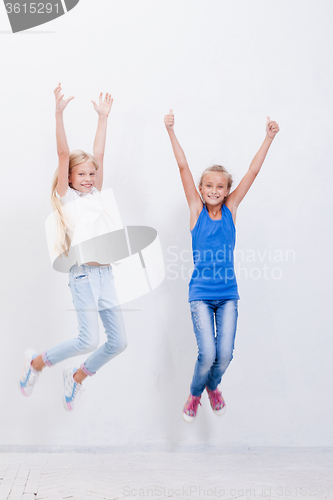 Image of Group of happy young girls jumping  on white background