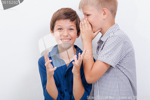 Image of Teenage boy whispering in the ear a secret to friendl on white  background