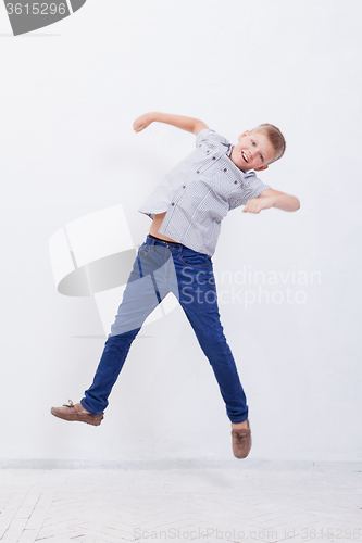 Image of happy young boy jumping  on white background