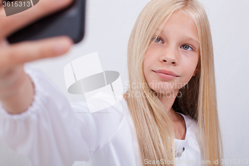 Image of pretty teen girl taking selfies with her smart phone