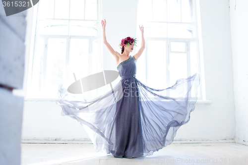 Image of The beautiful ballerina dancing in long gray dress 