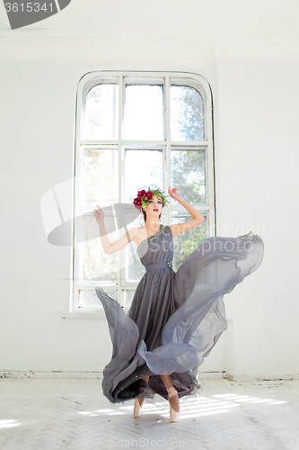 Image of The beautiful ballerina dancing in long gray dress 