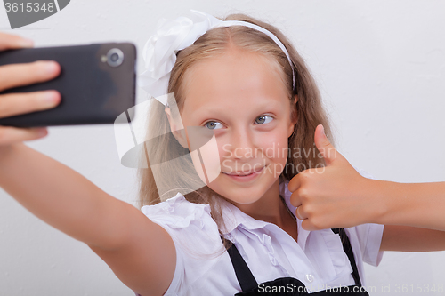 Image of pretty teen girl taking selfies with her smart phone