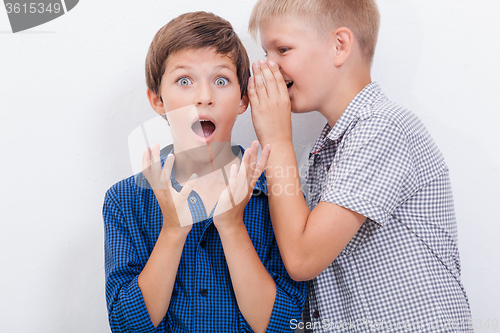 Image of Teenage boy whispering in the ear a secret to friendl on white  background