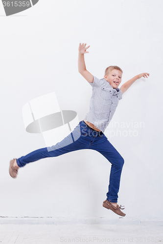 Image of happy young boy jumping  on white background