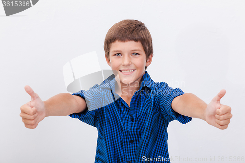 Image of Portrait of happy boy showing thumbs up gesture