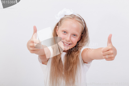 Image of Portrait of a beautiful girl showing thumbs up on white