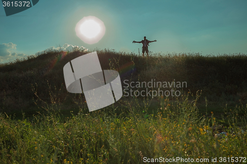 Image of Young caucasian man with backpack walking on a green meadow