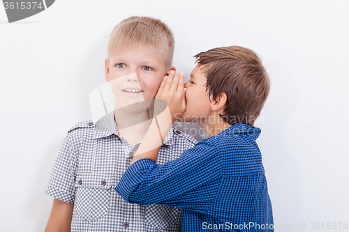 Image of Teenage boy whispering in the ear a secret to friendl on white  background