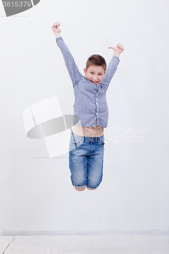 Image of happy young boy jumping  on white background