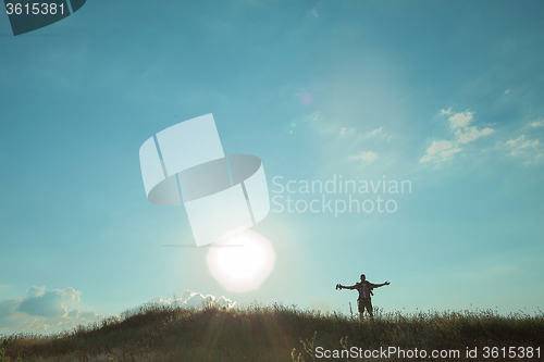 Image of Young caucasian man with backpack walking on a green meadow