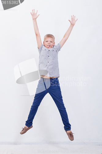 Image of happy young boy jumping  on white background