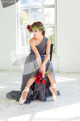 Image of The beautiful ballerina sirtting in long gray dress 