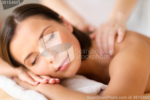 Image of beautiful woman in spa salon getting massage