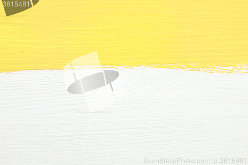 Image of Stripe of yellow paint over white wooden background