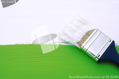 Image of Painting green surface with white paint