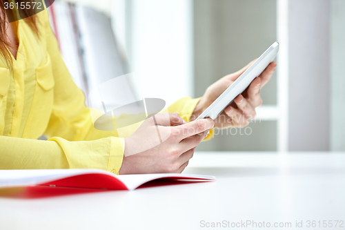 Image of close up of female hands with tablet pc at table